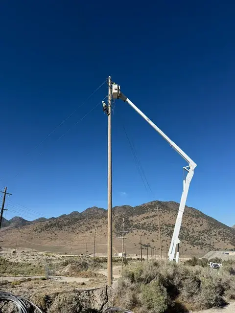 Bucket truck beside an overhead utility pole