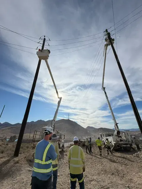 Field crew and equipment beside utility poles