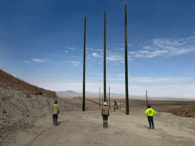 Field crew beside tall utility poles