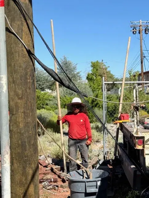 Field crew beside poles and equipment