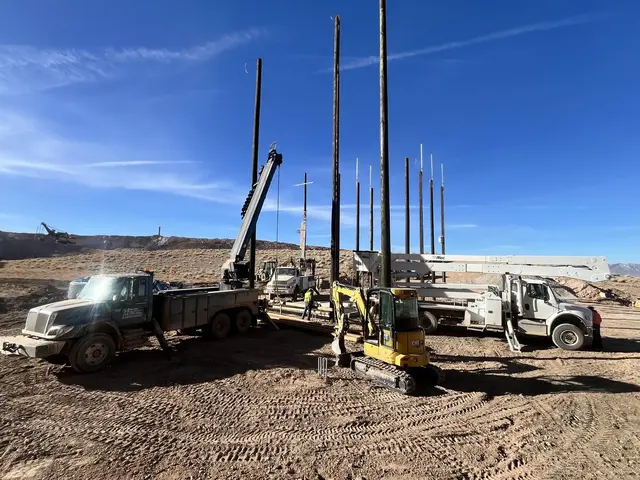 Bucket trucks and utility poles in the field