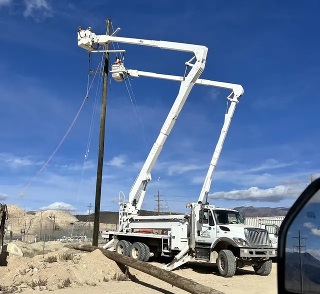 Field crew working from buckets beside an overhead pole